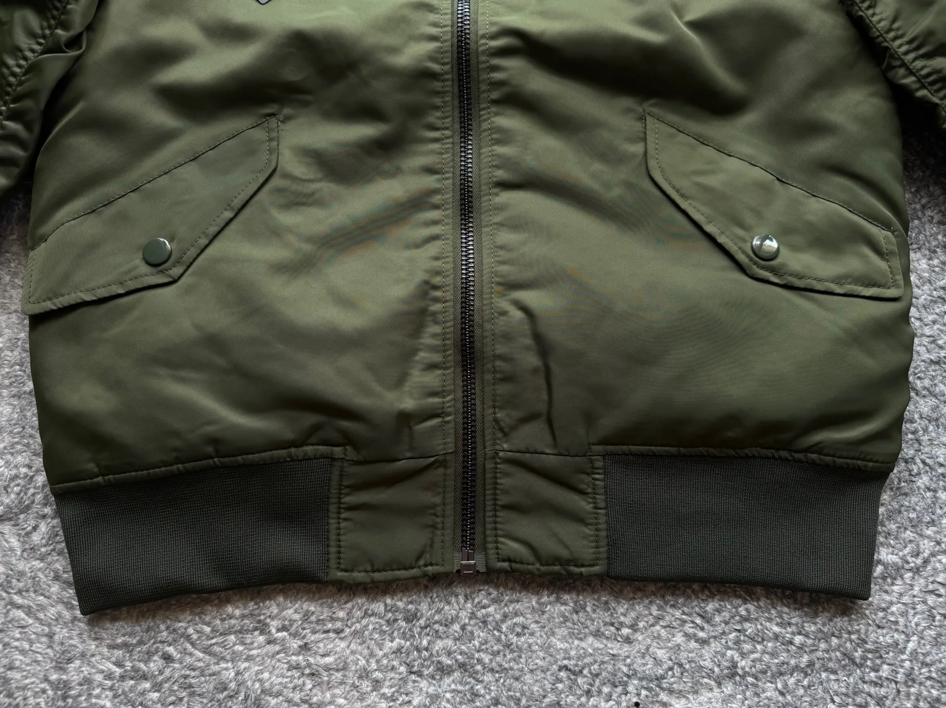 P360 Stone lsland Stone Island Medal Aviator Cotton Jacket The outer fabric is made of MA-1 flight nylon, which is a material specially used in flight and aviation. Flying nylon is a fabric specially used in flight and aviation. It is rarely used in ordinary clothing. The density of flying nylon is very high, so it is windproof and waterproof. When rain falls on the surface of the clothes, it will not penetrate immediately, but will form a small water droplet and slide off. This performance is a requirement for the development of modern jet technology. Because it is assumed that the pilot got caught in the rain before getting on the plane, he entered the cabin covered in rainwater. When flying at high altitude and at high speed, in a cabin without an environmental control system, water droplets will freeze on the pilot's body 2. Knitted baseball collar MA-1 uses a knitted collar. The collar is made of wool and can be snug around the neck and very warm. 3. Metal zippers We have very strict requirements on zippers, including smoothness and size. There was no zipper on the market that met the requirements, so we asked a zipper factory to customize a strong and durable metal zipper.  4. Double-threaded knitted cuffs The cuffs are made of double-threaded knitted fabric, narrow at the front and wide at the back. The narrow part can be tightened around the wrist to prevent wind from entering. The wide part has enough space when wearing multiple pieces under winter Color: Black Dark Army Green Size: M L.
